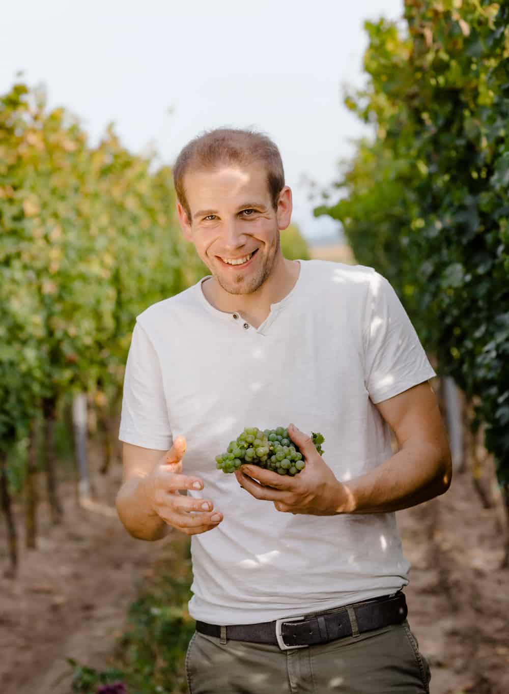 Stefan Pratsch in the vineyard with grapes